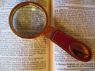 Bibel mit einer Lupe untersuchen